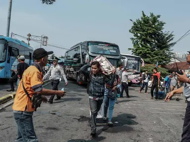 Petugas mengatur lalulintas di Terminal Kalideres, Jakarta, Kamis (30/5/2019). Menurut Badan Pengelola Transportasi Jabodetabek (BPTJ) puncak arus mudik di Terminal Kalideres diprediksi akhir pekan ini, mulai dari Jumat hingga Sabtu. (Liputan6.com/Faizal Fanani)