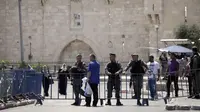 Tidak hanya di Masjid AL-Aqsa, petugas polisi Israel juga melakukan penjagaan ketat di luar gerbang Damaskus di Kota Tua Yerusalem, Sabtu (15/7). Umat muslim Palestina diperbolehkan melakukan ibadah asal tetap dalam penjagaan petugas. (AP/Mahmoud Illean)