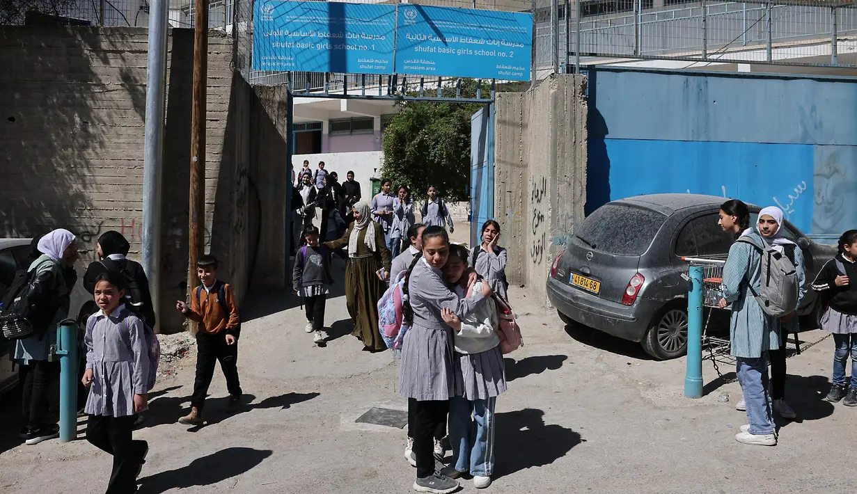 Siswi-siswi Palestina meninggalkan sekolah United Nations Relief and Works Agency for Palestine Refugees in the Near East atau Lembaga Bantuan dan Pekerjaan Perserikatan Bangsa Bangsa (PBB) untuk Pengungsi Palestina (UNRWA) di kamp pengungsi Shoafat, Yerusalem timur pada 8 Mei 2025. (AHMAD GHARABLI/AFP)