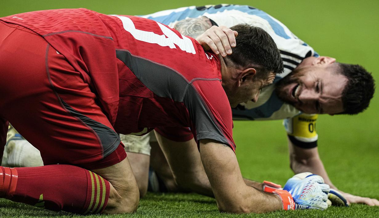Pemain Argentina, Lionel Messi (kanan) merayakan kemenangan timnya bersama kiper Emiliano Martinez setelah berhasil mengalahkan Belanda saat babak adu penalti pada perempat final Piala Dunia 2022 yang berlangsung di Stadion Lusail, Jumat (09/12/2022) waktu setempat. Laga yang awalnya imbang 2-2 hingga extratime 2x15 menit, dimenangkan oleh Argentina pada babak adu penalti dengan skor 4-3. (AP/Jorge Saenz)
