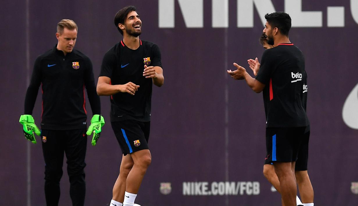 Andre Gomes (2kiri)  tertawa saat mendapat tepuk tangan Suarez pada sesi latihan di Sports Center FC Barcelona Joan Gamper, Sant Joan Despi (15/8/2017). Barcelona akan melawan Madrid pada leg kedua Piala Super Spanyol. (AFP/Lluis Gene)