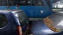 Tumpukan daun kering menempel di wiper kaca depan dan atap mobil dinas yang terparkir di area belakang Gedung DPR/MPR, Jakarta, Selasa (5/12). Belum ada kejelasan terkait nasib mobil-mobil serta bus dinas tersebut. (Liputan6.com/Johan Tallo)