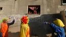 Badut tampil menghibur anak-anak Palestina, di Khan Younis, Jalur Gaza selatan pada Rabu (2/9/2020). Penampilan itu dilakukan di tengah lockdown yang diberlakukan oleh otoritas setempat menyusul lonjakan kasus virus corona. (MAHMUD HAMS/AFP)