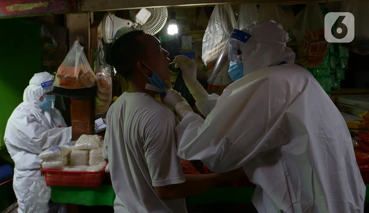 Petugas medis melakukan tes usap (swab test) ke pedagang Pasar Karang Anyar di Jakarta, Kamis (26/6/2020). Tes swab dengan metode PCR dilakukan secara masif setelah adanya pelonggaran PSBB, terutama di wilayah yang berpotensi tinggi menjadi tempat penularan Covid-19. (merdeka.com/Imam Buhori)