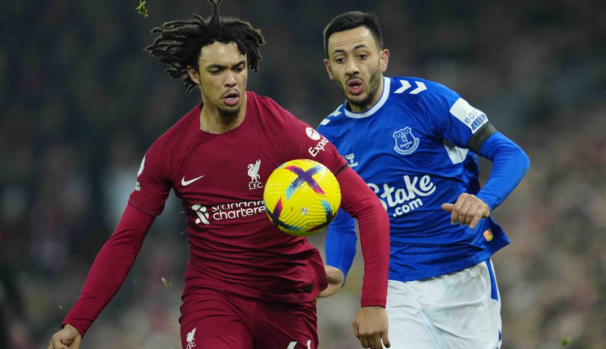 Pemain Liverpool, Trent Alexander-Arnold, berebut bola dengan pemain Everton, Dwight McNeil, pada laga Liga Inggris di Stadion Anfield, Selasa (14/2/2023). Bermain di kandang sendiri, The Reds memenangi derbi Merseyside dengan skor 2-0. (AP Photo/Jon Super)