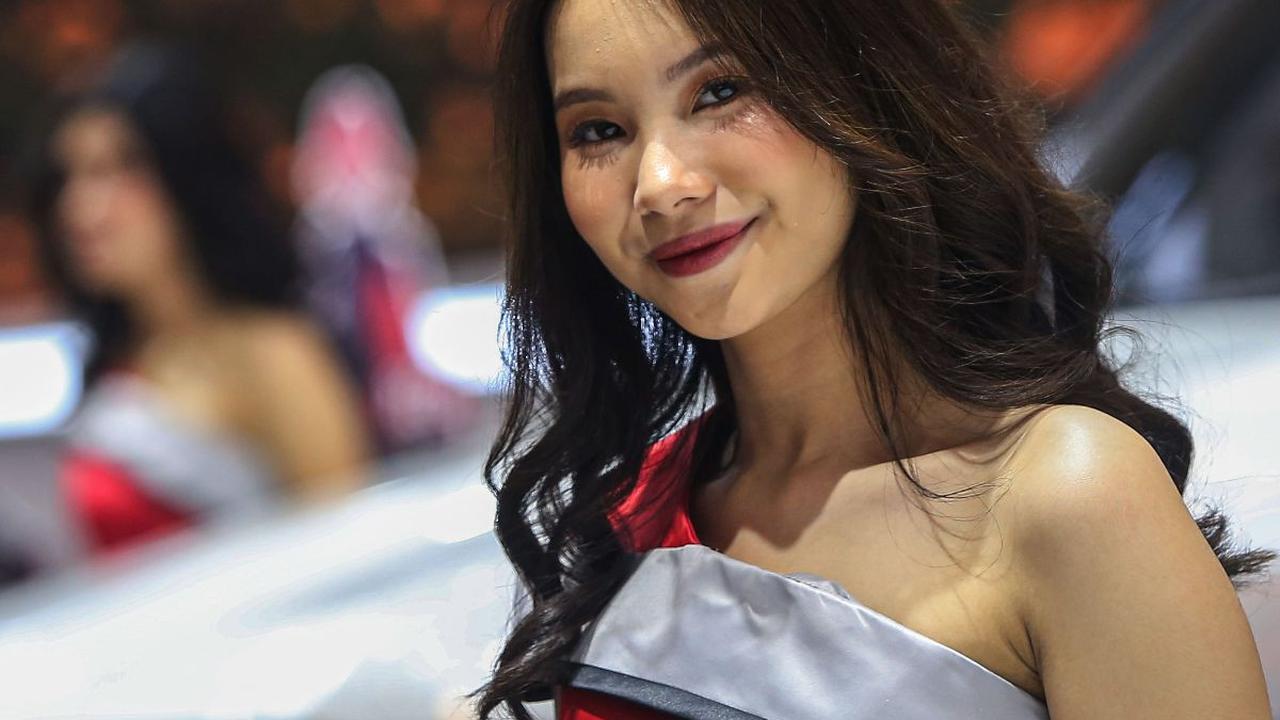 Seorang Sales Promotion Girl (SPG) berpose di sebuah mobil yang dipamerkan dalam ajang pameran Gaikindo Indonesia International Auto Show (GIIAS) 2024 di Indonesia Convention Exhibition (ICE), Kabupaten Tangerang, Banten, Kamis (18/7/2024). Kehadiran para