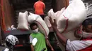 Pekerja tengah menurunkan beras yang akan di jual di Jakarta, Senin (21/12/2020). Kenaikan harga beras yang biasa terjadi saat momen akhir dan awal tahun diyakini tidak terjadi pada periode kali ini. (Liputan6.com/Angga Yuniar)