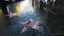 Bintang di Walk of Fame Hollywood atas nama Presiden Amerika Serikat (AS) Donald Trump yang rusak di Los Angeles, Rabu (25/7).  Bintang tersebut sudah hancur total, Hanya tersisa sebagian kecil sisi bintang yang terlihat utuh. (AP/Reed Saxon)