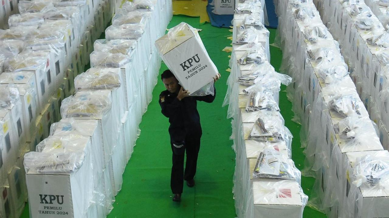 Petugas mengeluarkan logistik Pemilu 2024 dari GOR Tanah Abang untuk didistribusikan ke sejumlah Tempat Pemungutan Suara (TPS), Selasa (13/2/2024). Logistik pemilu&nbsp;berupa kotak suara, bilik suara, alat coblos dan bantalan ini akan disebar ke&nbsp;498