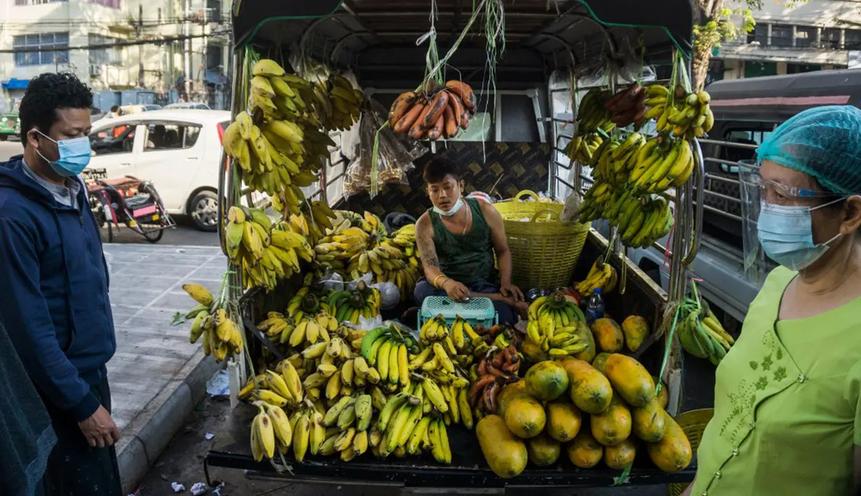 Seorang pria menjual pisang dari truk di sebuah pasar sehari setelah militer Myanmar merebut kekuasaan, Yangon, Myanmar, Selasa (2/2/2021). Militer Myanmar menahan pemimpin yang terpilih secara demokratis Aung San Suu Kyi dan memberlakukan keadaan darurat satu tahun. (STR/AFP)