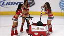 Ice Girls dari Chicago Blackhawks selain menghibur dengan tarian mereka bertugas membersihkan lapangan hoki es sebelum pertandingan National Hockey League (NHL) dimulai. (Jonathan Daniel/Getty Images/AFP)