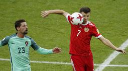 Aksi pemain Rusia, Dmitry Poloz (kanan) mengahalau bola dari kejaran pemain Portugal, Adrien Silva pada laga grup A Piala Konfederasi 2017 di Spartak Stadium, Moscow, (21/6/2017). Portugal menang 1-0. (AP/Alexander Zemlianichenko)