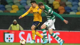 Pemain Atletico Madrid, Angel Correa berebut bola dengan pemain Sporting CP, Fabio Coentrao pada leg kedua perempat final Liga Europa di Estadio Jose Avalade, Jumat (13/4). Atletico Madrid tetap maju ke semifinal meski kalah 0-1  (AP/Armando Franca)