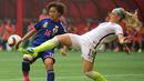 Bek AS, Julie Johnston (19) menendang bola dari kejaran pemain Jepang, Iwabuchi di final Piala Dunia wanita di BC Place, Vancouver, Kanada, Senin (6/7/2015). Amerika mengalahkan Jepang dengan skor 5-2. (Reuters/Anne Marie Sorvin)