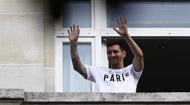 Megabintang Lionel Messi melambai kepada para fans dari balkon hotel Royal Monceau di Paris pada Selasa (10/8/2021). Lionel Messi telah mencapai kesepakatan dengan Paris Saint-Germain (PSG) mengenai kepindahan ke klub Prancis tersebut. (Sameer Al-DOUMY/AFP)