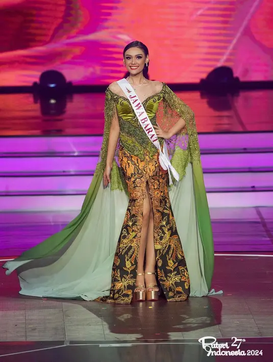 Di malam Grand Final Puteri Indonesia, Tata juga tampil cantik dengan kebaya yang telah dimodifikasi. Siluet kebaya menjadi atasan dengan leher terbuka berwarna hijau velvet dengan bordir dan jahitan yang rumit. Bagian lengan dari busana ini tersambung dengan train panjang yang menjuntai hingga ke lantai, berwarna hijau serasi. [Foto: Instagram/harashtata]