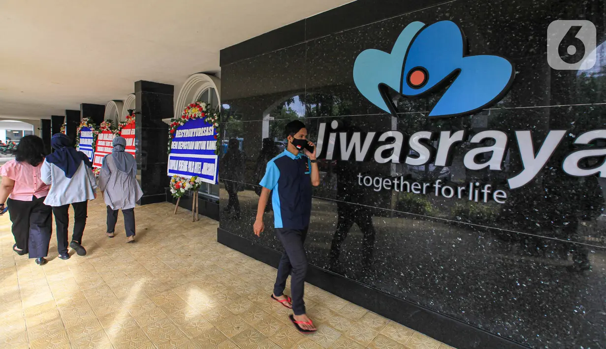 Sejumlah orang berjalan dekat karangan bunga di halaman Kantor PT Asuransi Jiwasraya (Persero), Jakarta, Selasa (15/12/2020). Karangan bunga tersebut berisi ucapan dukungan kepada manajemen baru Jiwasraya dalam penyelamatan polis melalui program restrukturisasi. (Liputan6.com/Faizal Fanani)