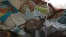 Zenobia Ansualve duduk di ruang tamu bersama kucingnya Cenizo, di Caracas, Venezuela, pada 18 Agustus 2021. Ansualve (88) yang tinggal sendiri dan tidak meninggalkan rumahnya sejak awal pandemi COVID-19, mengatakan hidup dengan $20 sebulan dari menyewakan kamar miliknya. (AP Photo/Ariana Cubillos)