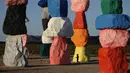 Seorang anak berlari melewati instalasi seni Seven Magic Mountains karya seniman Ugo Rondinone di Las Vegas, Amerika Serikat, Selasa (7/4/2020). Susunan batu berwarna neon memungkinkan Anda untuk mengambil foto-foto yang sangat menarik. (AP Photo/John Locher)