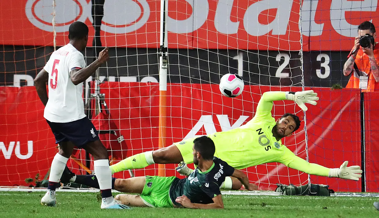 Gelandang Liverpool, Georginio Wijnaldum saat memasukan bola yang dijaga kiper Sporting CP,  Renan Ribeiro dalam laga uji coba di Stadion Yankee, Amerika Serikat, Kamis (25/7/2019). Liverpool ditahan imbang Sporting dengan skor 2-2. (AFP Photo/Al Bello)