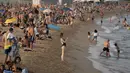 Seorang wanita mengambil foto saat menikmati cuaca panas di pantai di Barcelona, Spanyol, Kamis (12/8/2021). Layanan cuaca nasional Spanyol memperingatkan suhu bisa mencapai 44 derajat Celcius (111 derajat Fahrenheit) di beberapa daerah dalam beberapa hari mendatang. (AP Photo/Joan Mateu Parra)