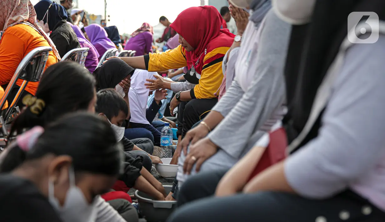 Sejumlah anak mencuci kaki ibunya pada aksi cuci kaki ibu massal di Jakarta, Minggu (18/12/2022). Aksi yang diikuti sebanyak ratusann peserta itu bertujuan untuk meningkatkan rasa cinta kasih kepada ibu , khususnya dalam rangka memperingati Hari Ibu. (Liputan6.com/Faizal Fanani)