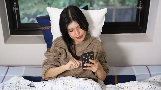 wanita desember pegang ponsel