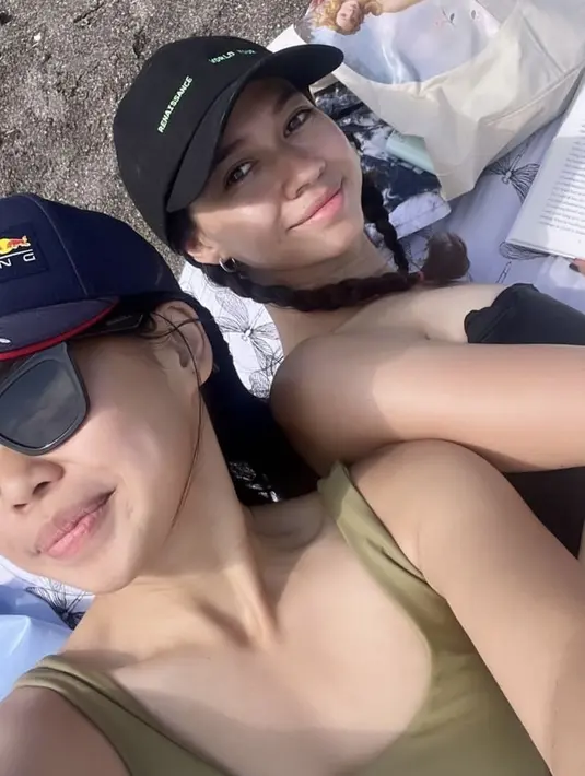 Bersantai di pantai, Yuki mengenakan kemben hitam serasi dengan topi capnya. Lalu Reina mengenakan tank top hijau armynya.  [@yukikt]