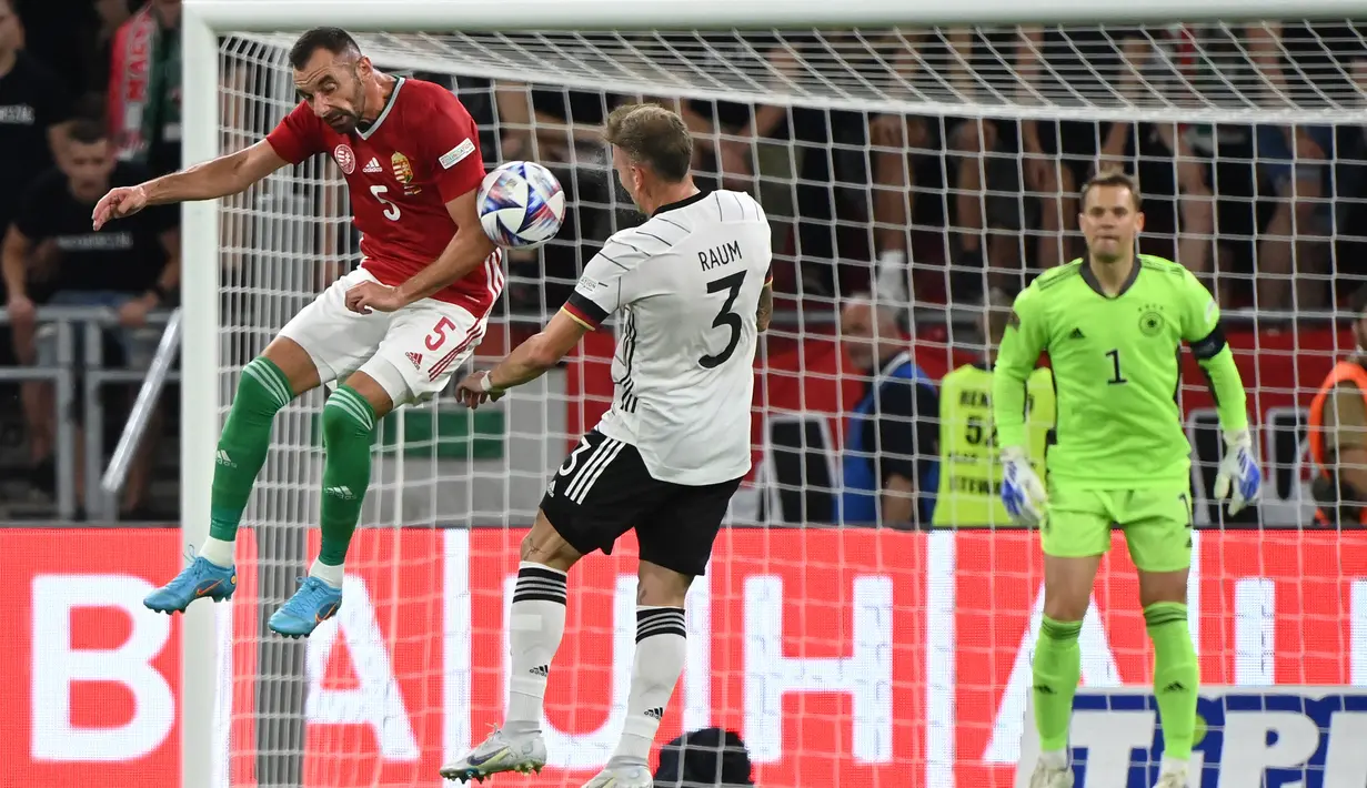 Bek Hungaria, Attila Fiola dan gelandang Jerman David Raum berebut bola dalam pertandingan grup A3 UEFA Nations League di Puskas Arena di Budapest, Minggu (12/6/2022). Jerman bermain imbang atas Hungaria 1-1. (AFP/Attila Kisbenedek)