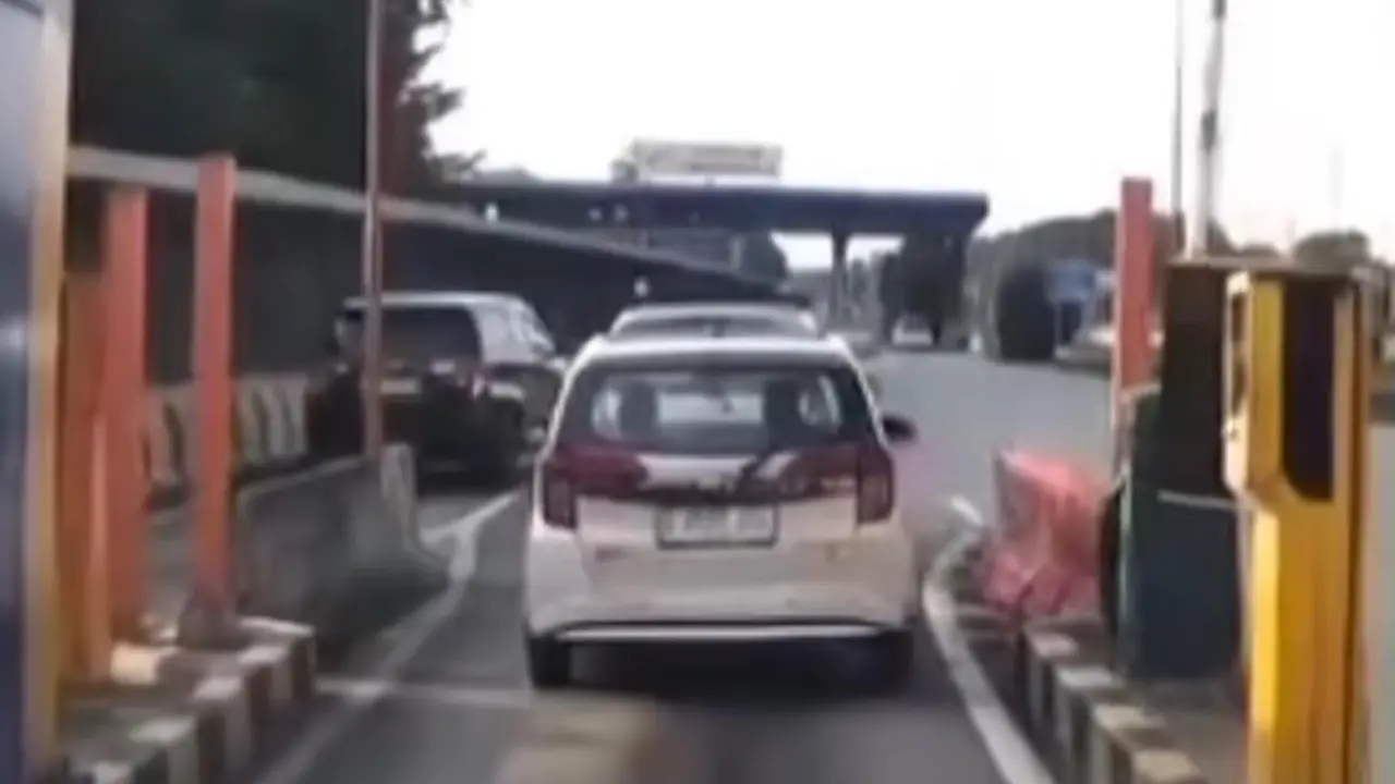 Pengemudi mobil menerobos gerbang tol di kawasan Depok.