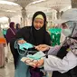 Petugas haji membagikan masker kepada jemaah di halaman Masjid Nabawi, Madinah. Pemerintah mengimbau para jemaah haji Indonesia mewaspadai penularan MERS-CoV. (Foto: MCH PPIH 2023)