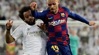 Pemain Barcelona, Martin Braithwaite (kanan) berebut bola dengan bek Real Madrid, Marcelo pada lanjutan pertandingan La Liga di Santiago Bernabeu, Minggu (2/3/2020).  Real Madrid membungkam Barcelona 2-0 dan merebut puncak klasemen dari Barcelona. (JAVIER SORIANO/AFP)