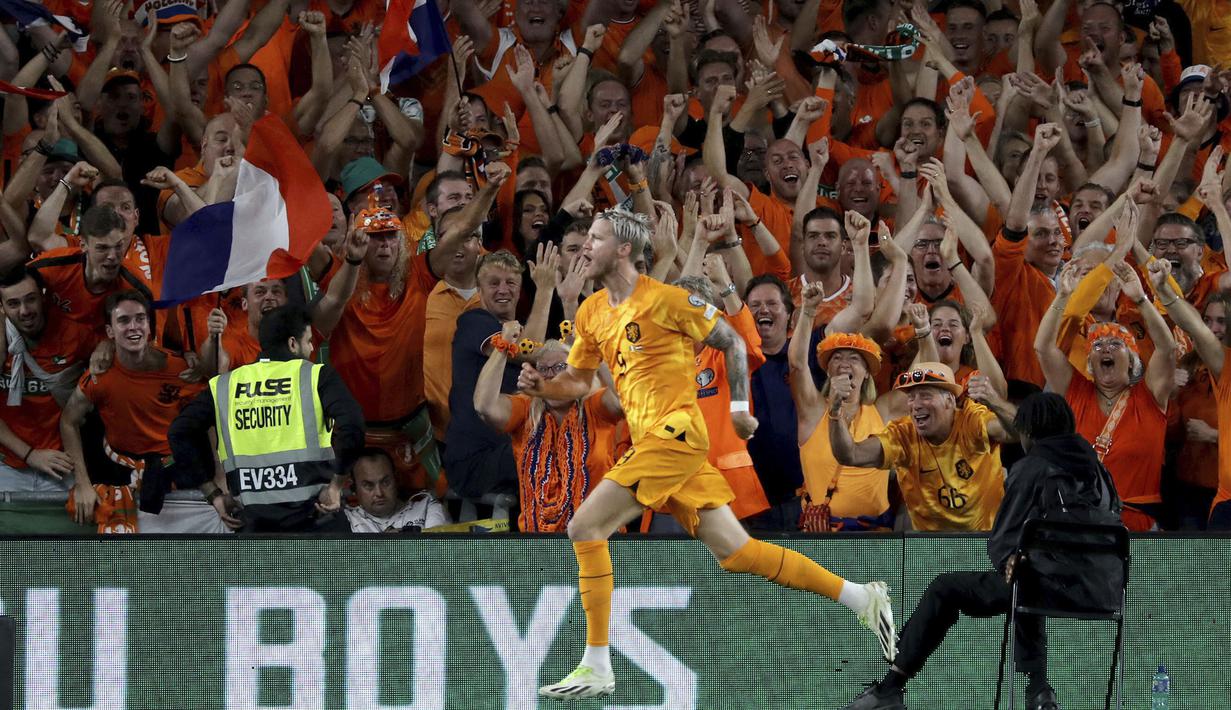 Pemain Timnas Belanda, Wout Weghorst, melakukan selebrasi dengan berlari ke arah suporter setelah mencetak gol ke gawang Timnas Irlandia dalam pertandingan grup B Kualifikasi Euro 2024 yang berlangsung di Aviva Stadium, Dublin, Senin (11/9/2023) dini hari WIB. (AP/PA/Donall Farmer)