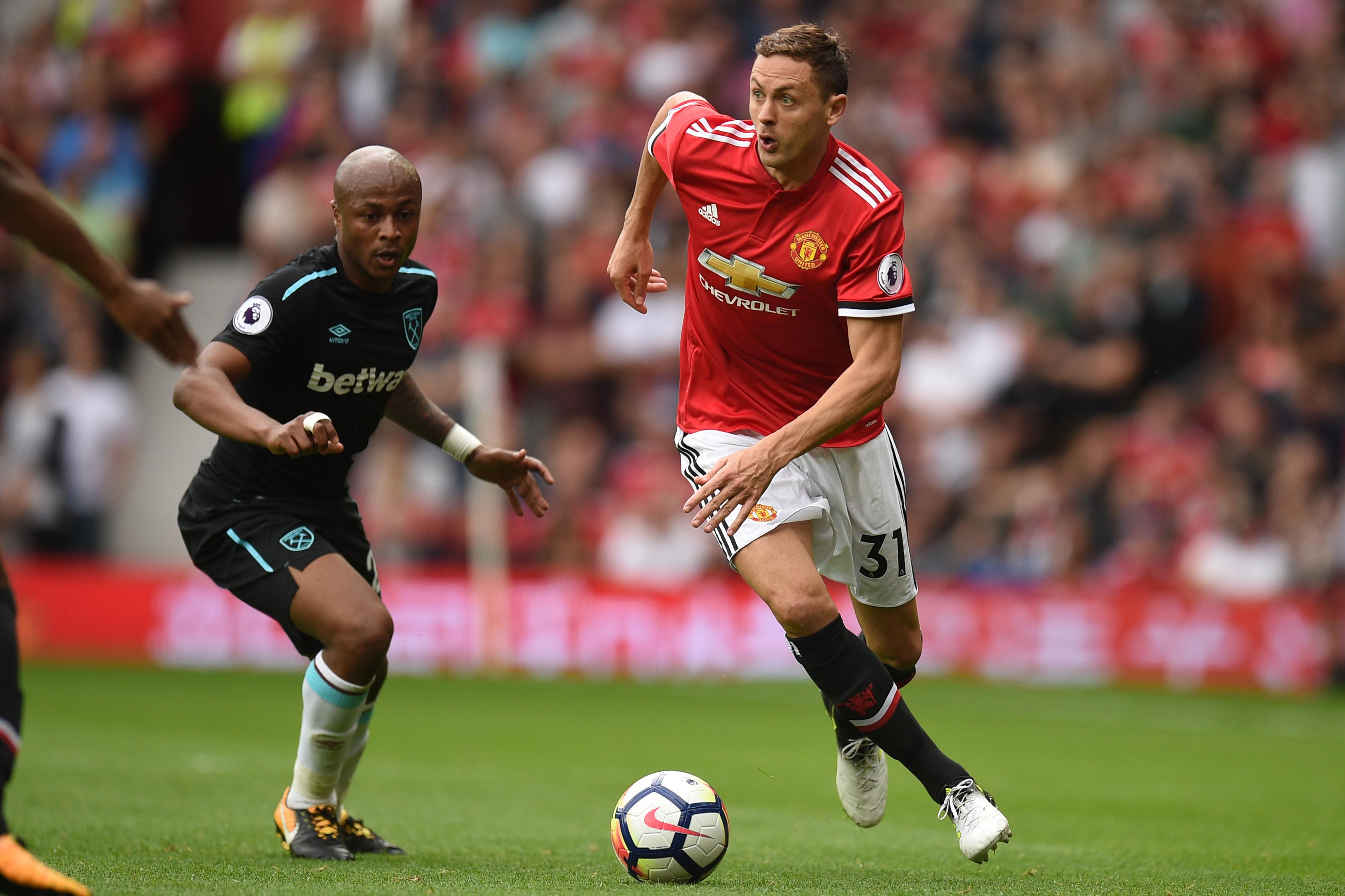 Gelandang Manchester United (MU), Nemanja Matic (kanan), coba lewati striker West Ham United, Andre Ayew, pada laga di Old Trafford, Minggu (13/8/2017). (AFP/Oli Scarff)