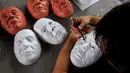 Mahasiswa seni rupa memotong topeng Presiden Rodrigo Duterte untuk perayaan Halloween di Universitas Filipina, Kota Quezon, Filipina (13/10). Topeng Duterte diyakini akan banyak diburu warga selama parayaan Halloween. (REUTERS/Romeo Ranoco)