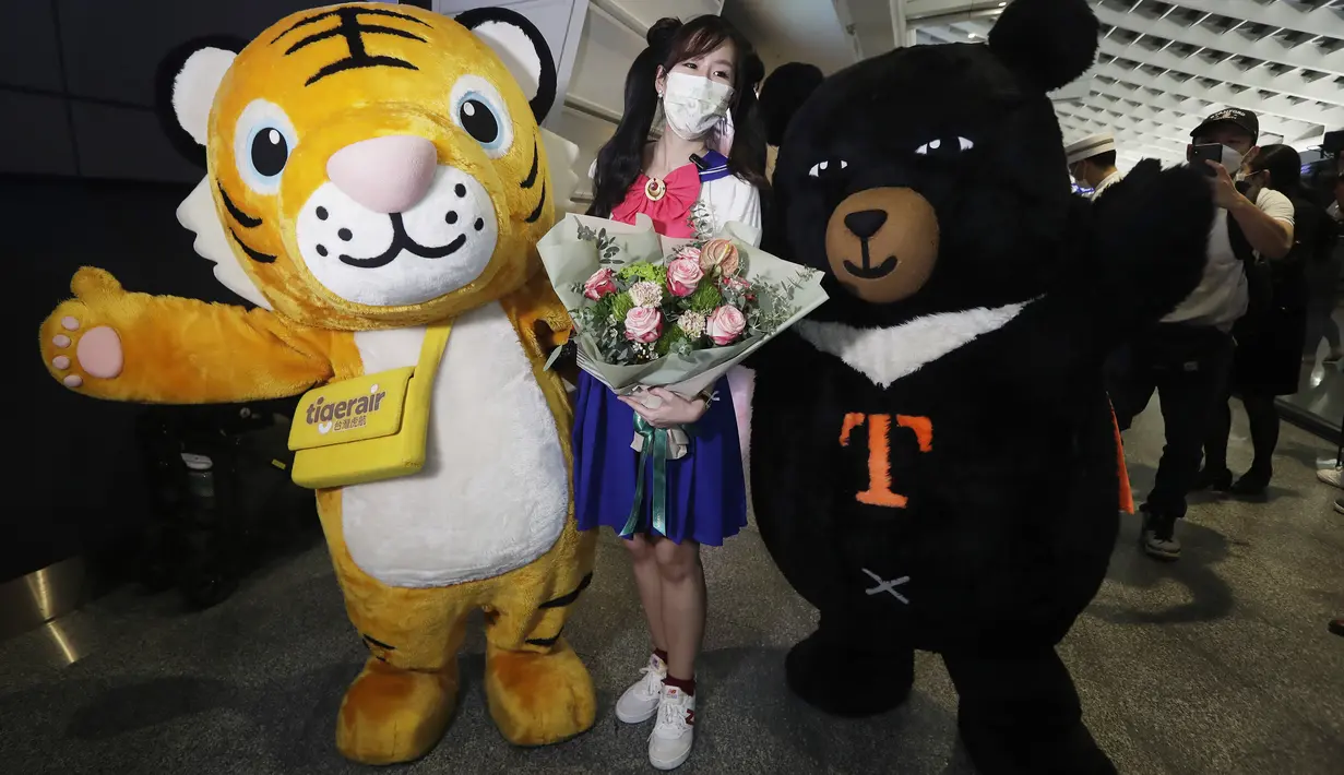 Seorang pelancong asing berpose untuk foto setelah tiba di Bandara Internasional Taoyuan di Taoyuan, Taiwan Utara, Kamis (13/10/2022). Taiwan sempat menutup semua perbatasan serta menerapkan aturan wajib karantina untuk para turis asing demi menjaga jumlah infeksi covid-19 tetap rendah. (AP Photo/Chiang Ying-ying)