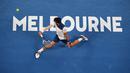Gaya Novak Djokovic melakukan backhand ke arah petenis Korea, Hyeon Chung pada ajang Australia Terbuka 2018 di Melbourne,  (22/2/2018). Djokovic kalah 6-7, 5-7, 6-7. (AFP/William West)