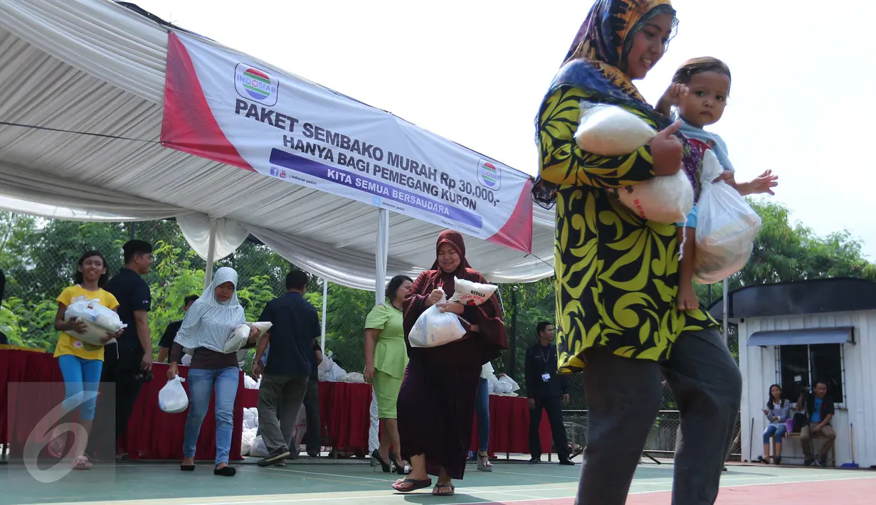 Warga membawa sembako usai mendapatkan paket sembako murah yang diadakan Indosiar di Joglo, Jakarta, Senin (13/6). Paket berisikan 5 kg beras, 2 liter minyak goreng, 1 kg gula pasir dan 1 kg tepung terigu dijual Rp 30 ribu‎. (Liputan6.com/Angga Yuniar)