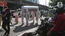 Petugas gabungan dari Kecamatan Cilandak dan Polsek Cilandak mengarak instalasi peti mati jenazah Covid-19 di kantor kecamatan Cilandak, Jakarta, Jumat (28/8/2020). Sosialisasi tersebut dilakukan untuk memberikan peringatan akan bahaya penularan virus Covid-19. (Liputan6.com/Herman Zakharia)