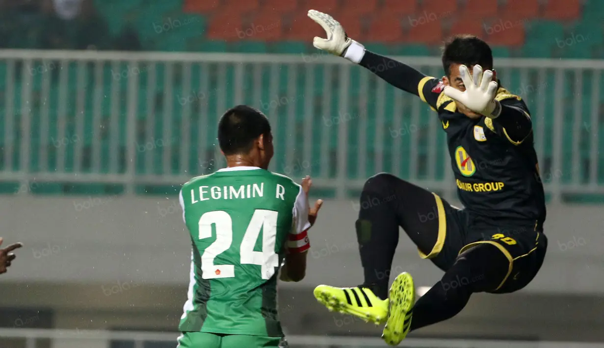 Pemain PS TNI, Legimin Raharjo berebut bola dengan kiper Barito Putra, Imam Arief Fadilah pada laga Torabika SC 2016 di Stadion Pakansari, Bogor, Jumat (22/7/2016). (Bola.com/Nicklas Hanoatubun)