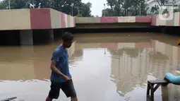 Warga melihat banjir yang mengenangi underpass Kemayoran, Jakarta, Minggu (2/2/2020). Banjir kembali merendam underpass Kemayoran, Jakarta Pusat. Akibatnya, akses jalur tersebut pun terputus alias tak bisa dilalui kendaraan. (Liputan6.com/Angga Yuniar)