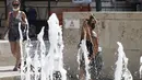 Seorang perempuan menyegarkan diri di air mancur Ara Pacis di pusat kota Roma, Rabu (11/8/2021). Gelombang panas yang berkelanjutan akan berlangsung hingga akhir pekan dengan suhu diperkirakan mencapai lebih dari 40 derajat Celcius di banyak bagian Italia. (Cecilia Fabiano/LaPresse via AP)