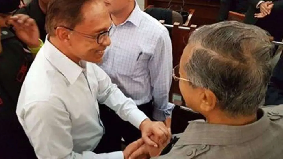 Anwar Ibrahim dan Mahathir Mohamad saling bersalaman ruang pengadilan pada September 2016 (AFP)