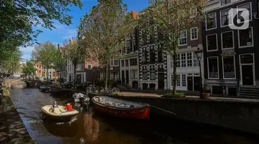 Sebuah kapal berlayar melewati kanal di kota Amsterdam, Belanda, Selasa (22/05/2024). (merdeka.com/Arie Basuki)