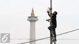 Pekerja memasang CCTV di Kawasan Monumen Nasional, Jakarta, Kamis (3/11). Pemasangan CCTV tersebut untuk meningkatkan keamanan di sekitar Monas. (Liputan6.com/Gempur M Surya)