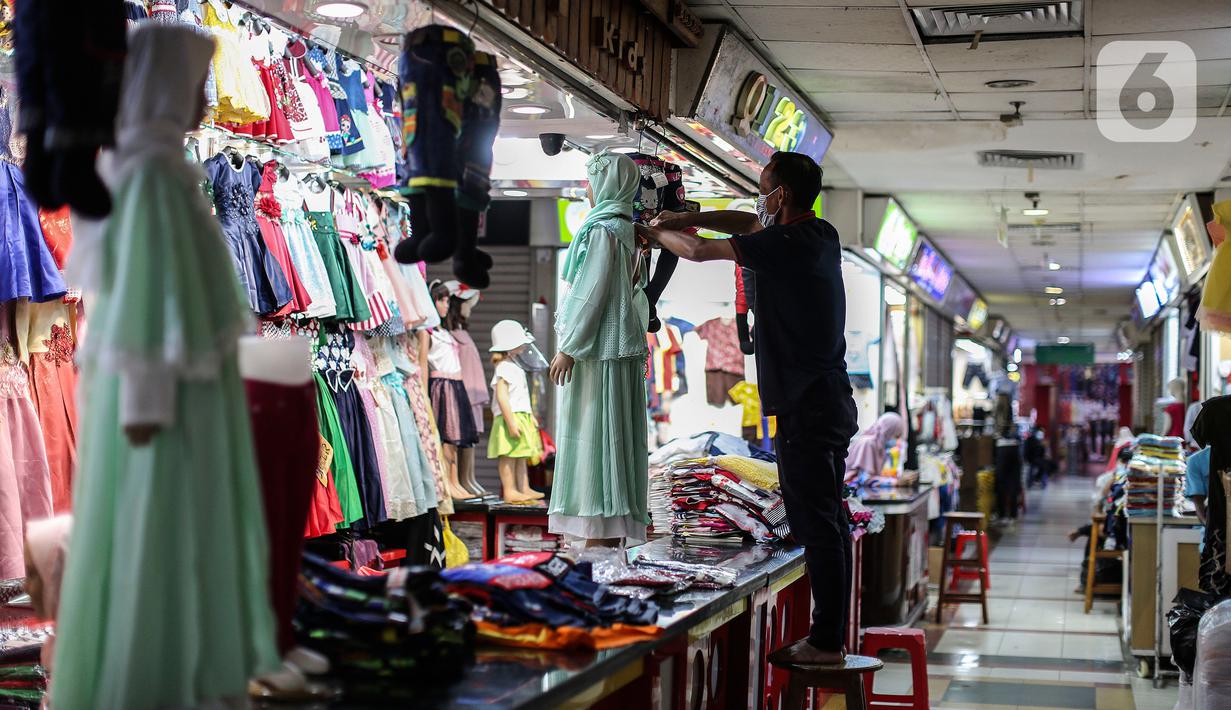 Pedagang pakaian menata dagangannya di Pasar Tanah Abang, Jakarta, Selasa (27/7/2021). Pasar Tanah Abang yang kembali dibuka mulai Senin (26/7) mewajibkan pengunjung serta pedagang menunjukkan sertifikat vaksinasi COVID-19 untuk masuk ke pasar. (Liputan6.com/Johan Tallo)