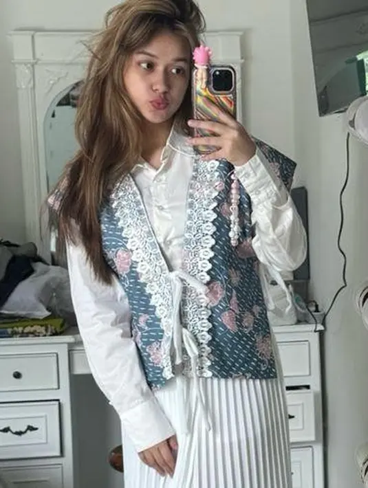 Dipermanis dengan  sling bag mutiara warna putih senada dengan outfit yang dikenakannya. [@rklopper]