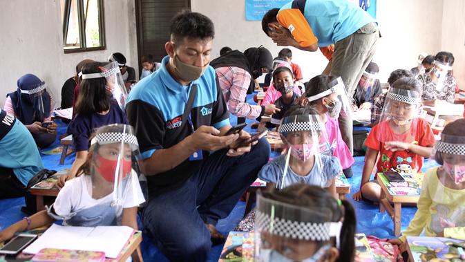 Kepala Program Sekolah Relawan, Abdul Manaf bersama para siswa yang menerima bantuan Mobile Wifi. Sekolah Relawan juga mengajarkan dari awal bagaimana cara mengakses internet untuk belajar online. (Foto: Liputan6.com)