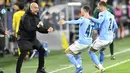 Pelatih Manchester City, Pep Guardiola merayakan gol yang dicetak gelandang Phil Foden ke gawang Borrusia Dortmund pada pertandingan leg kedua perempat final Liga Champions di stadion Signal Iduna Park di Dortmund, Jerman, Kamis (15/4/2021). City menang atas Dortmund 2-1. (AP Photo/Martin Meissner)