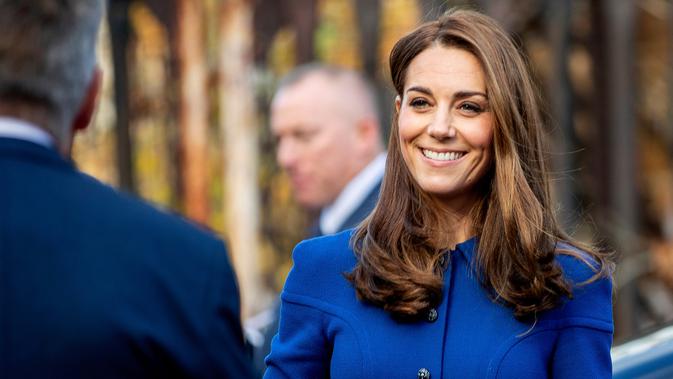 Kate Middleton tiba untuk mengunjungi Centrepoint, badan amal yang membantu tunawisma, di Barnsley, Inggris, Rabu (14/11). Ditemani Pangeran William, Kate tampil sederhana dengan rambutnya yang dibiarkan terurai. (Charlotte Graham/Pool via AP)